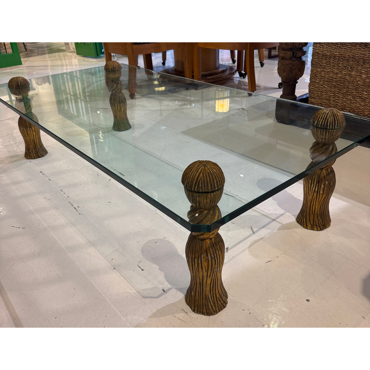 Mid-Century Modern Coffee Table in the manner of Phyllis Morris, featuring a rectangular glass top supported by four ornate gilt-finished tassel-shaped legs.